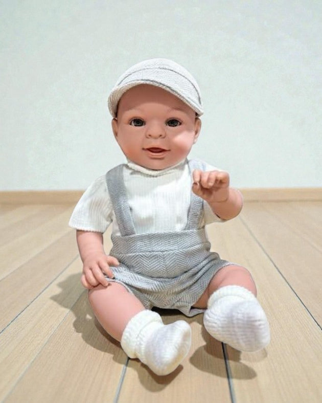 Boy Bebenita doll with brown eyes wearing grey herringbone overalls and white ribbed top