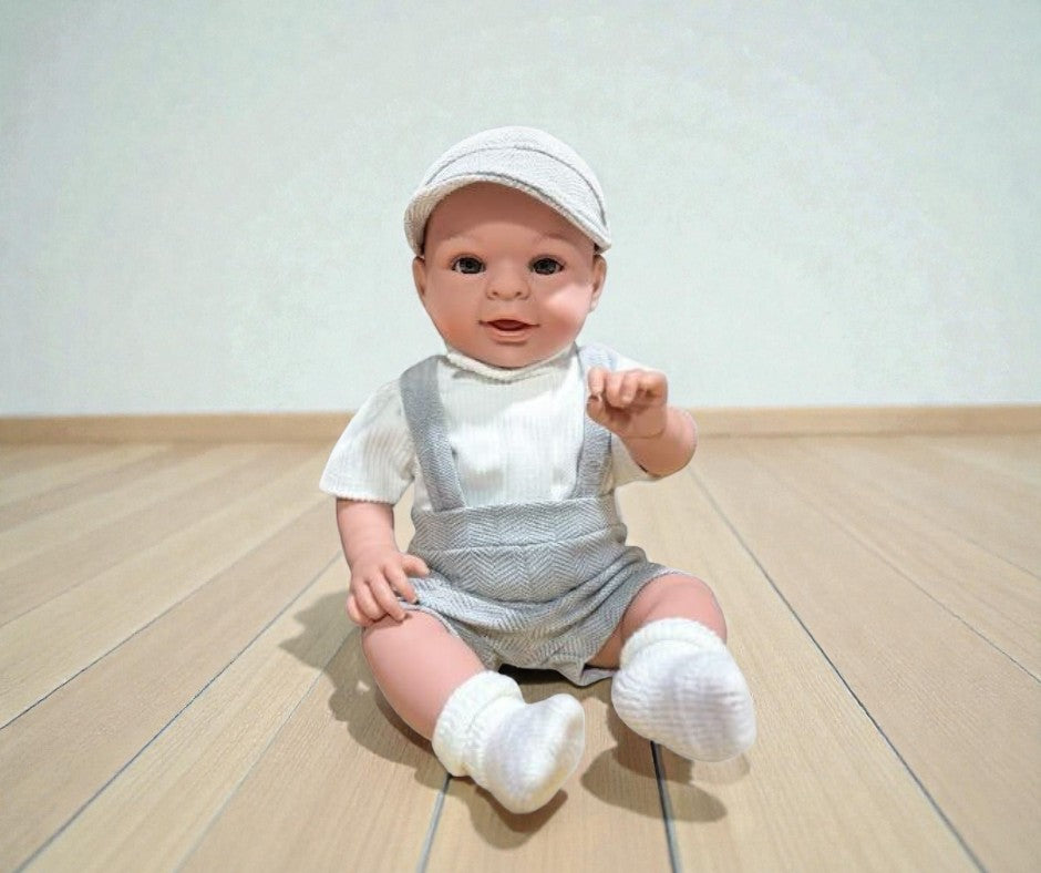 Boy Bebenita doll with brown eyes wearing grey herringbone overalls and white ribbed top