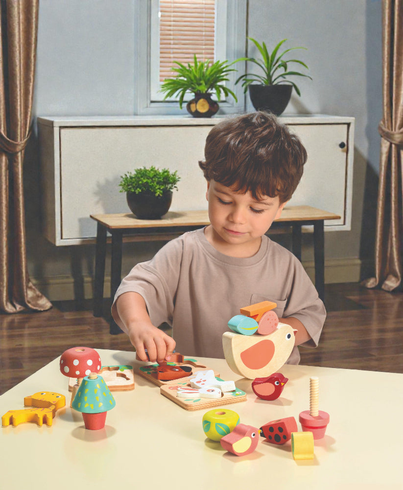 Child playing with wooden toys at a table in a room with plants and furniture.