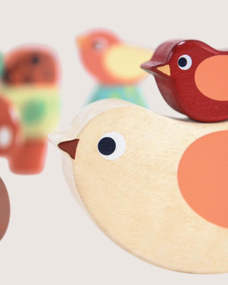 Wooden toys including a bird, rabbit, and butterfly on a light background