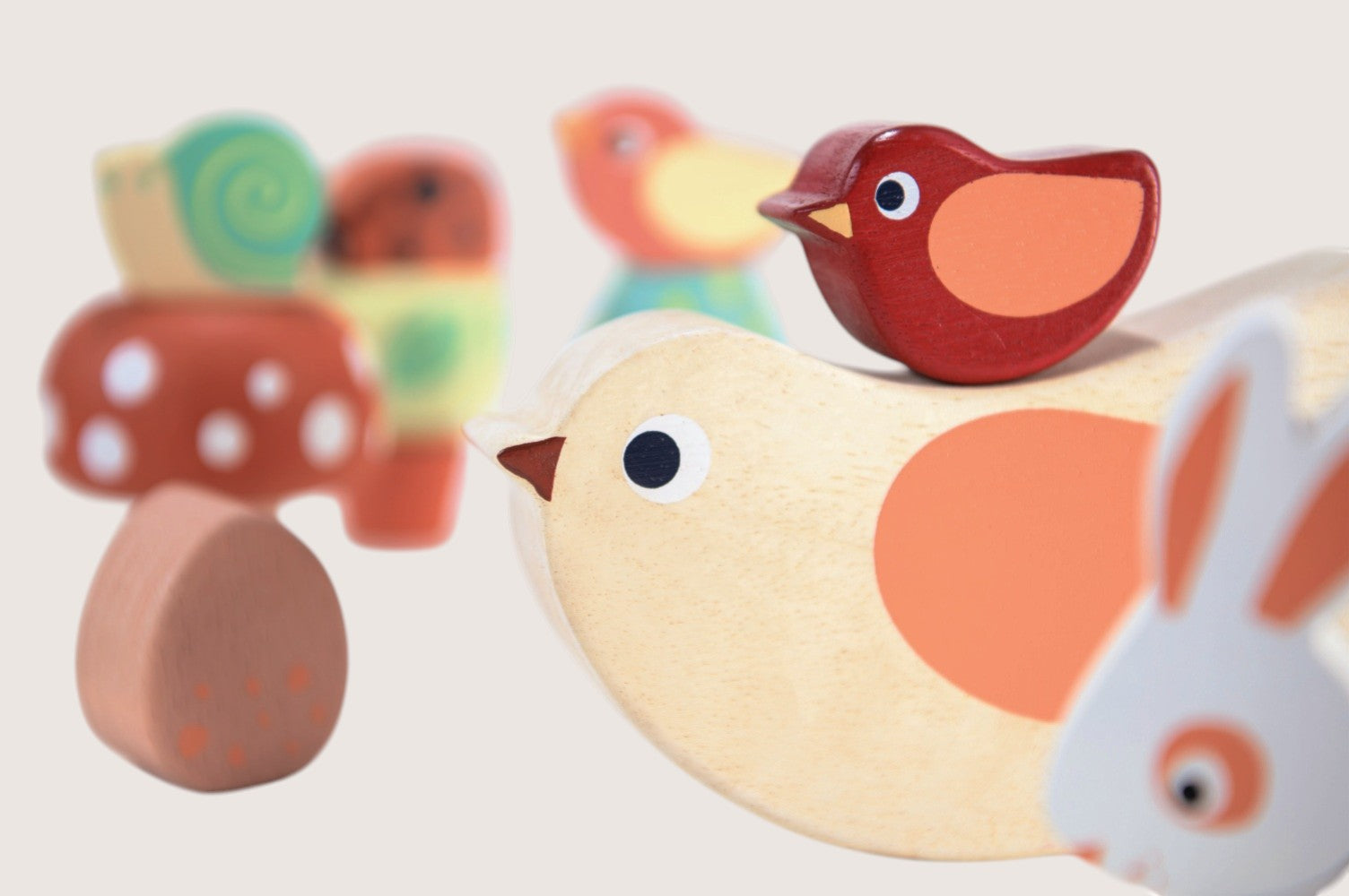 Wooden toys including a bird, rabbit, and butterfly on a light background
