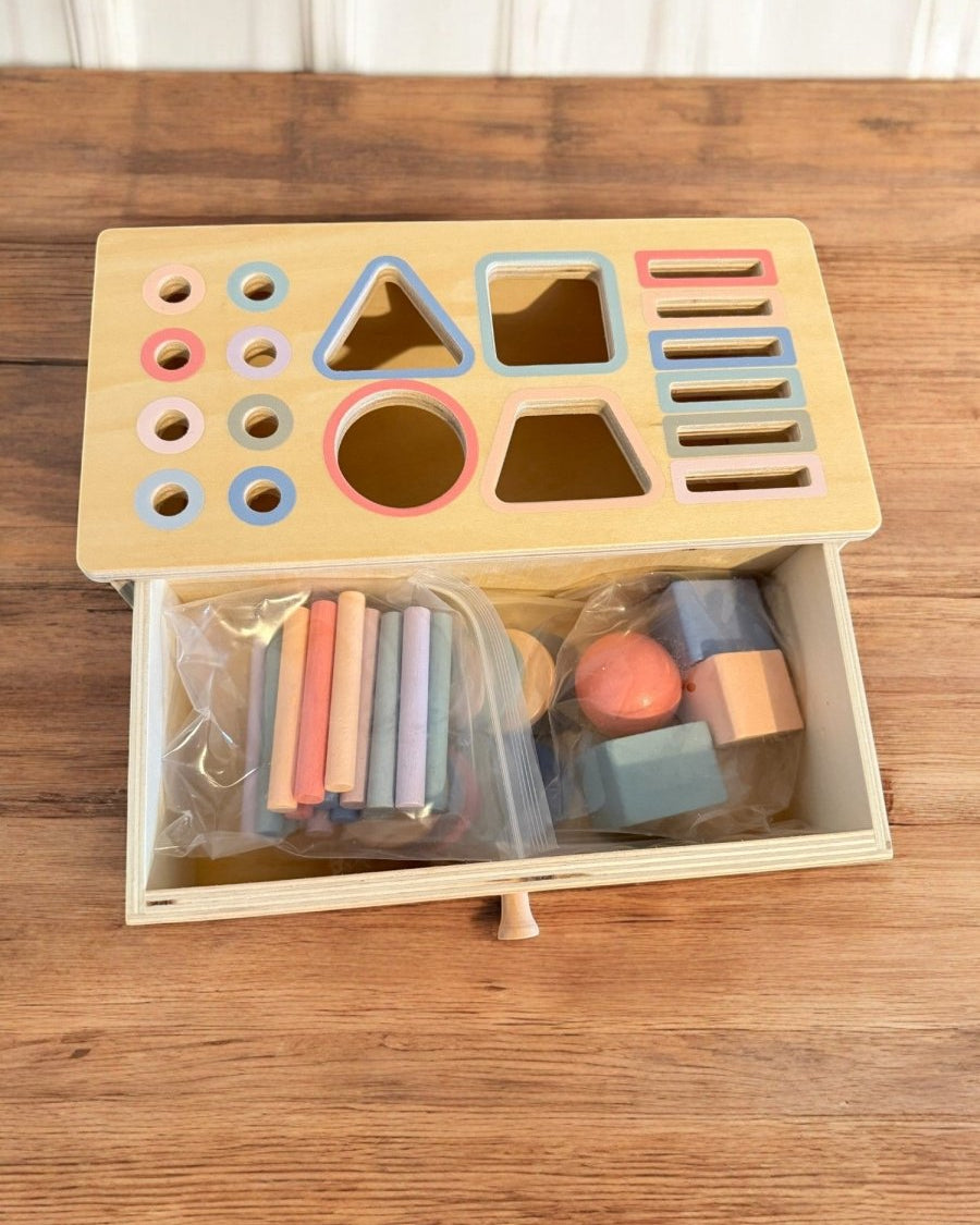 Close-up of wooden shape sorter showing precise craftsmanship and color-coded openings
