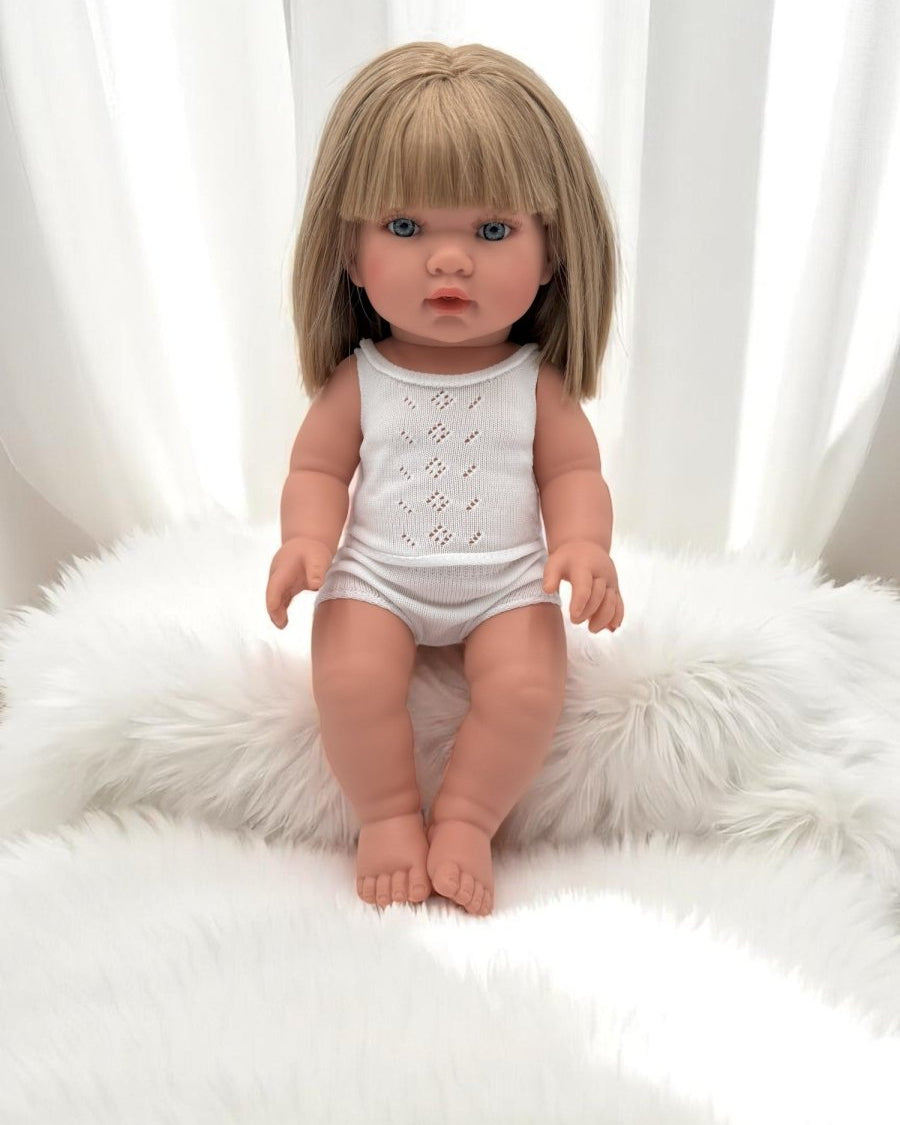 European-crafted baby girl doll with blonde hair in elegant white ensemble