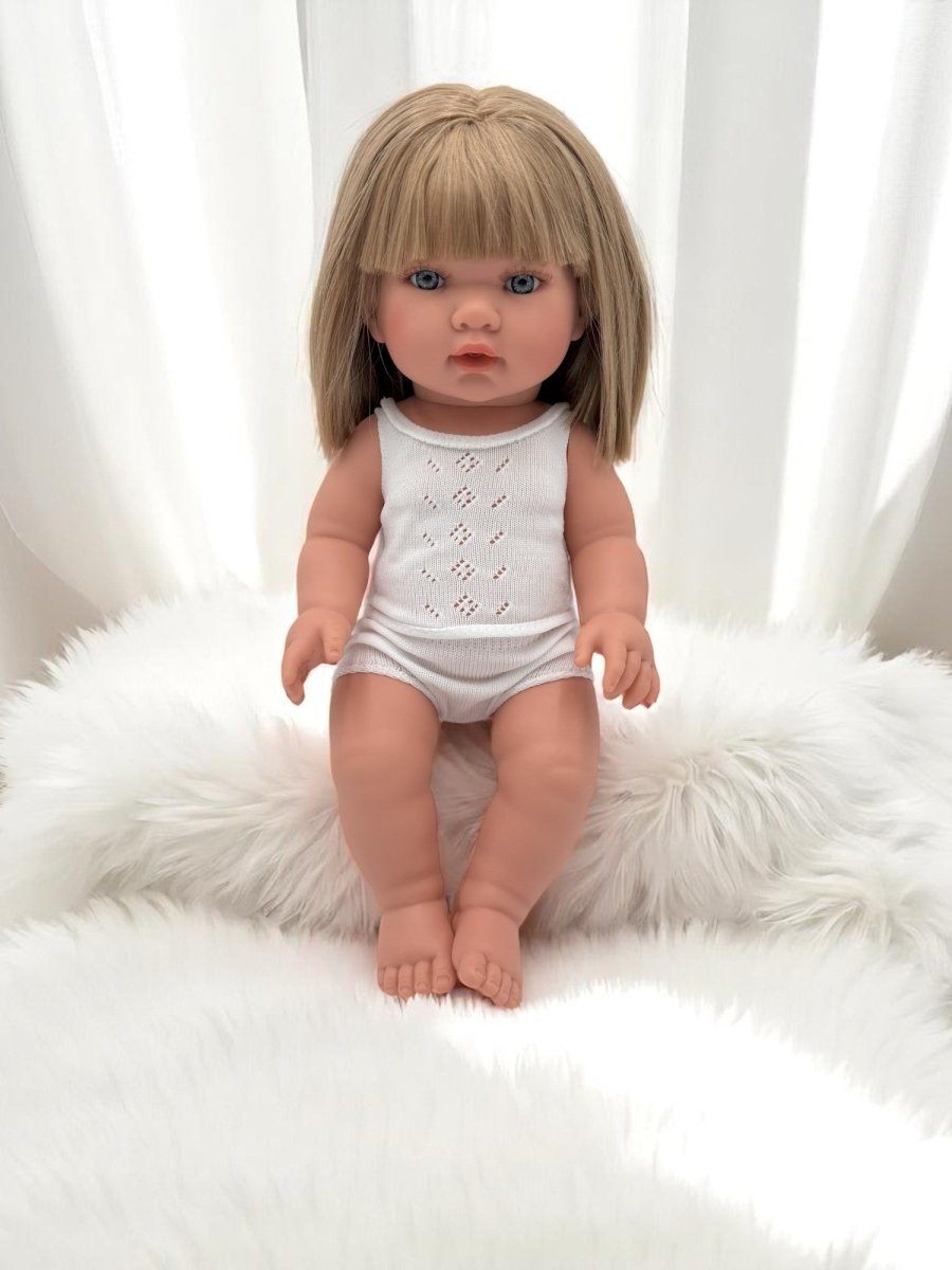 European-crafted baby girl doll with blonde hair in elegant white ensemble