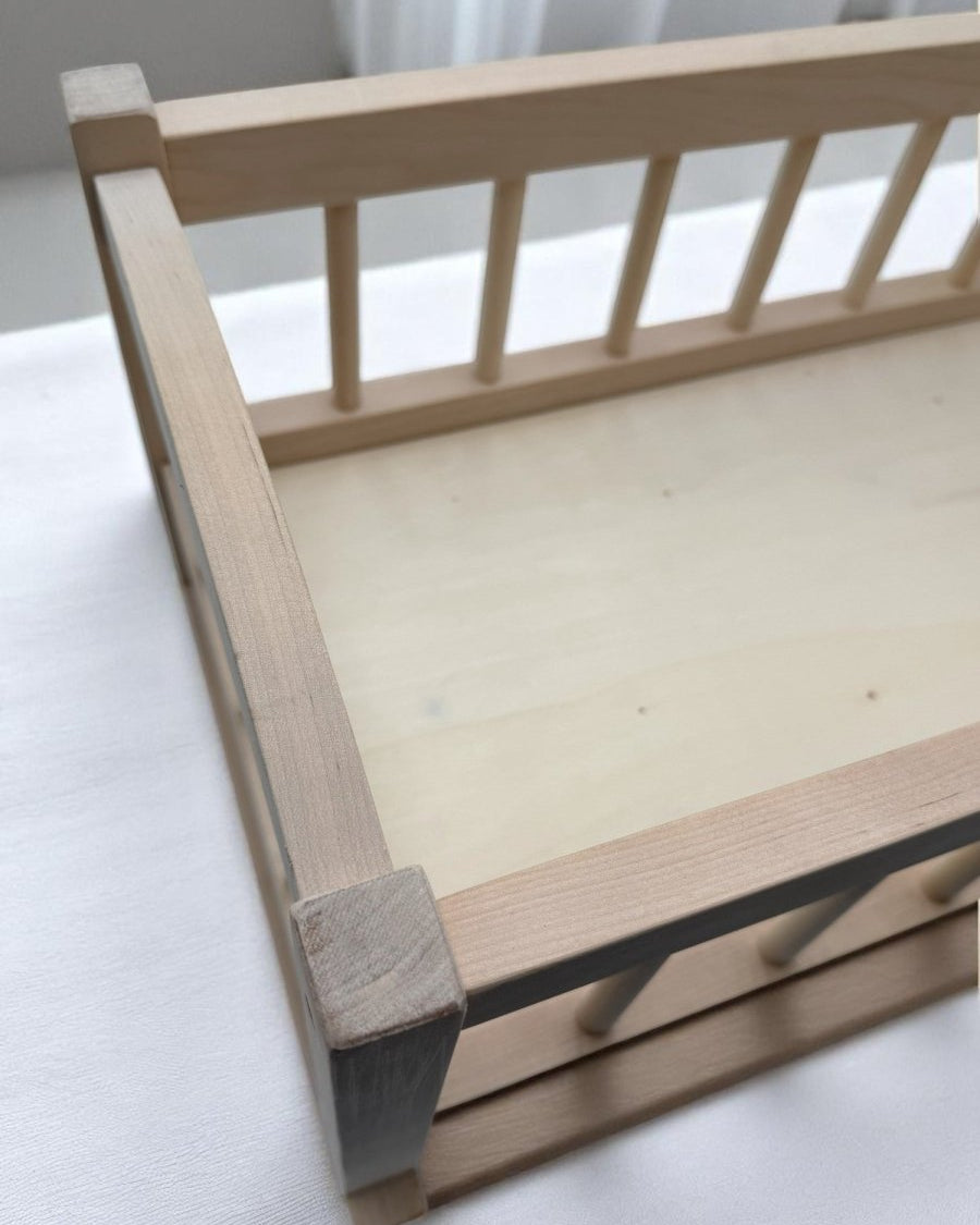 Wooden baby doll bed with spacious interior dimensions for realistic doll care and pretend play