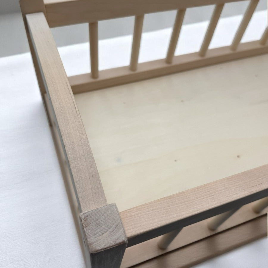 Wooden baby doll bed with spacious interior dimensions for realistic doll care and pretend play