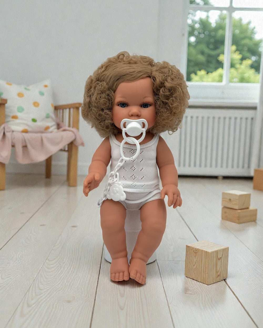 Artisan crafted girl doll showing bouncy blonde curls and sweet curious expression