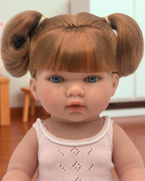 Close-up of Sydney doll's lifelike face with blue eyes and freckles
