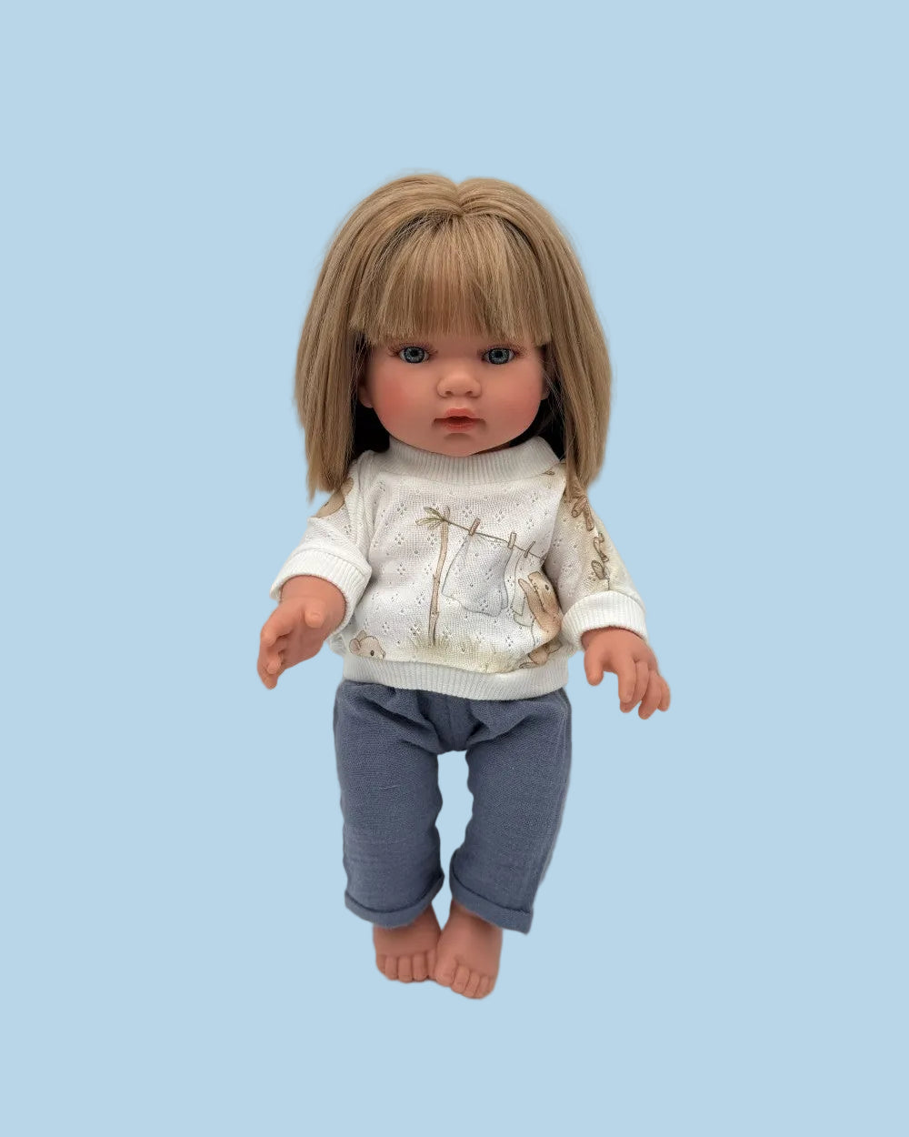Handmade doll sweater and pants set laid flat, showing bunny print sweater and coordinating pants