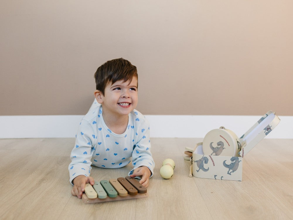 Child playing with a wooden toy on a wooden floor