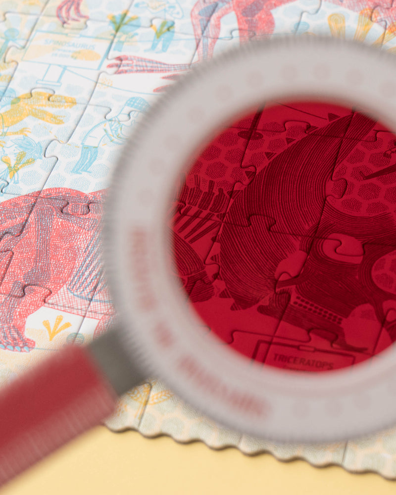 Magnifying glass over a colorful map with a red heart design