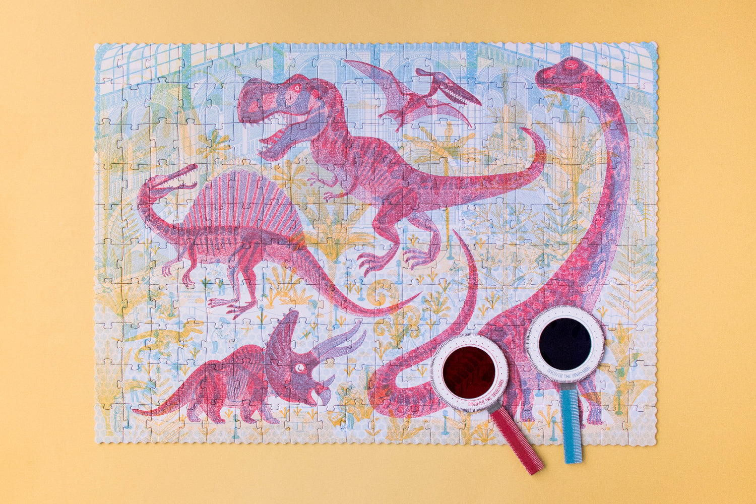 Dinosaur-themed puzzle on a yellow background with two cups and a straw.