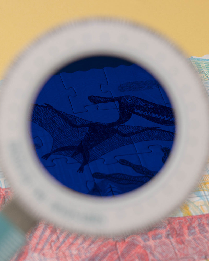 Close-up of a blue object through a magnifying glass on a colorful background