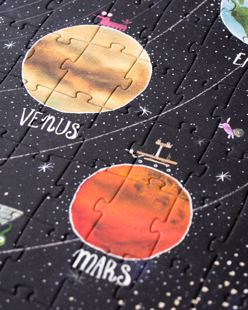 Solar system-themed puzzle with planets and astronauts on a black background