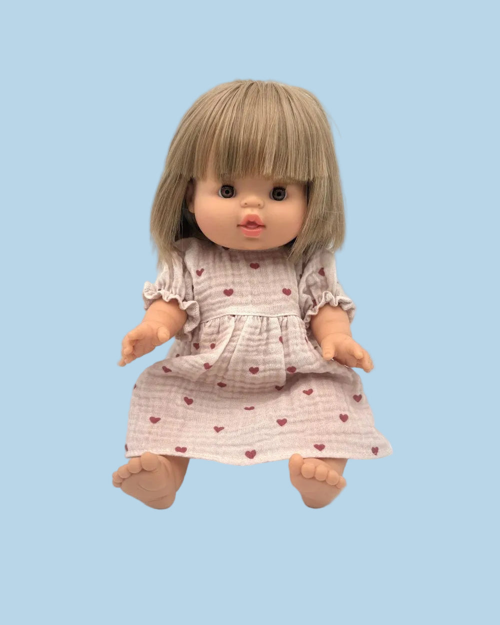 Doll with a dress featuring heart patterns on a light blue background