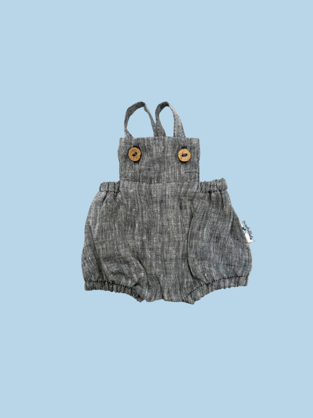 Blue denim romper with suspenders on a white background