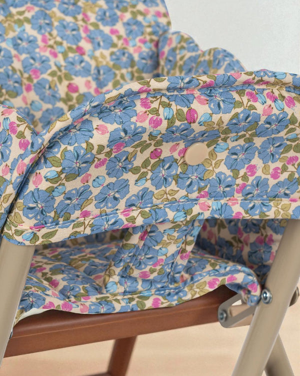 Close-up of quilted Fleur Rosier print cushion showing cornflower blue flowers with pink accents and green leaves on cream background
