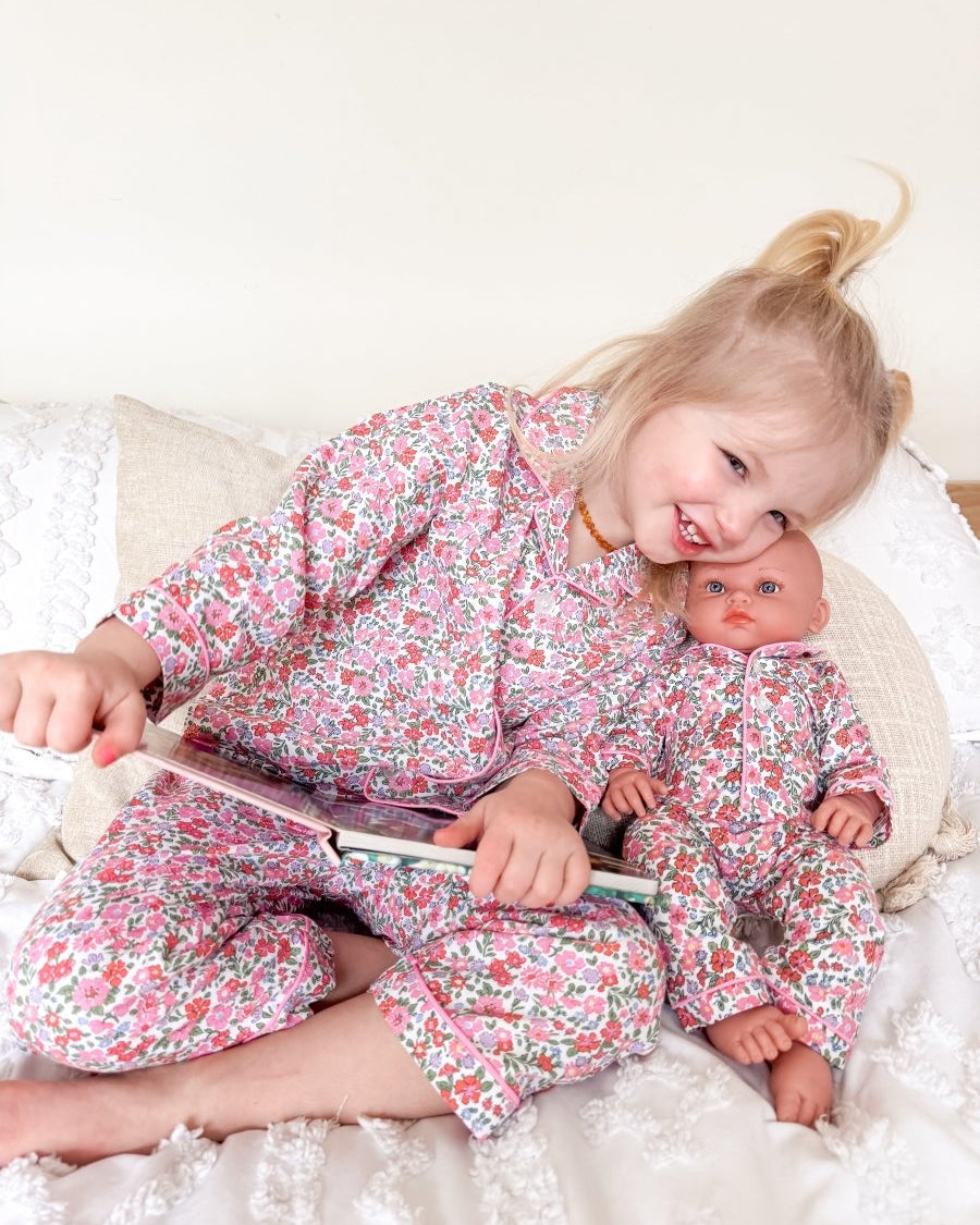 Girl and doll wearing floral pjs