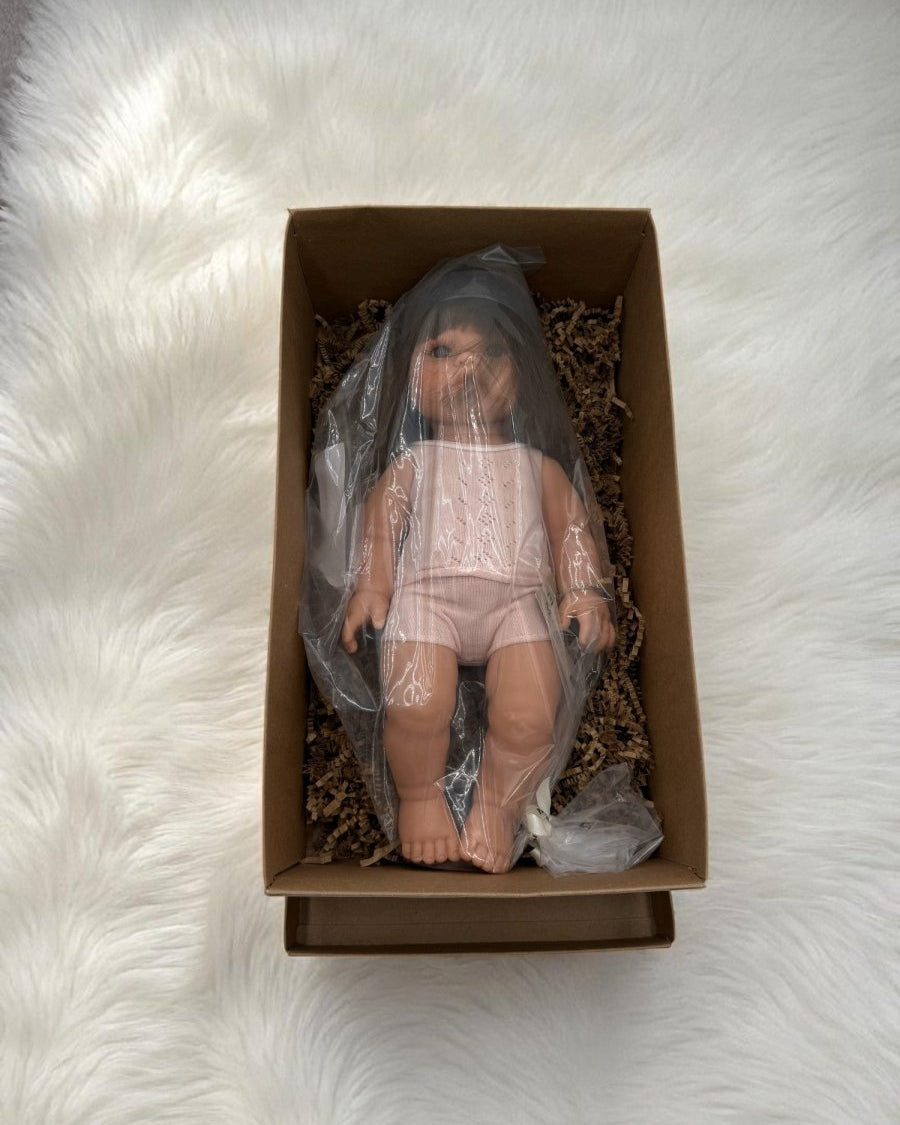 Realistic doll Milan with brunette straight hair wearing pink ribbed pajama set for screen-free play