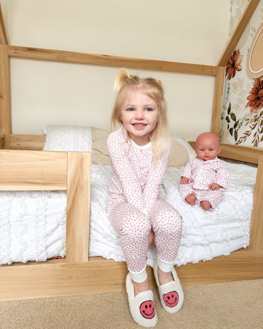 Girl and doll in pink pajamas