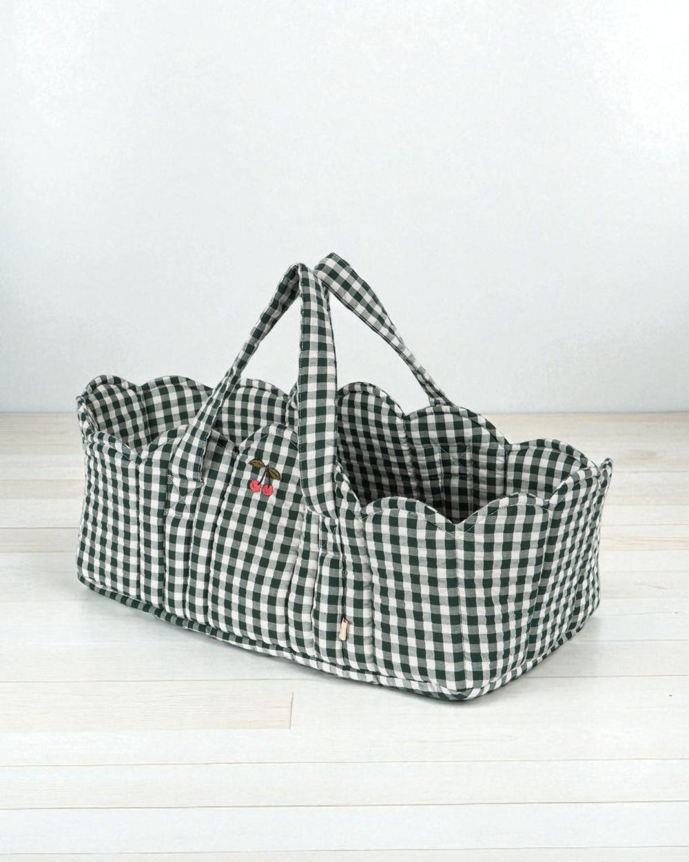Green check doll bassinet with classic gingham pattern, sturdy handles and soft cotton interior lining