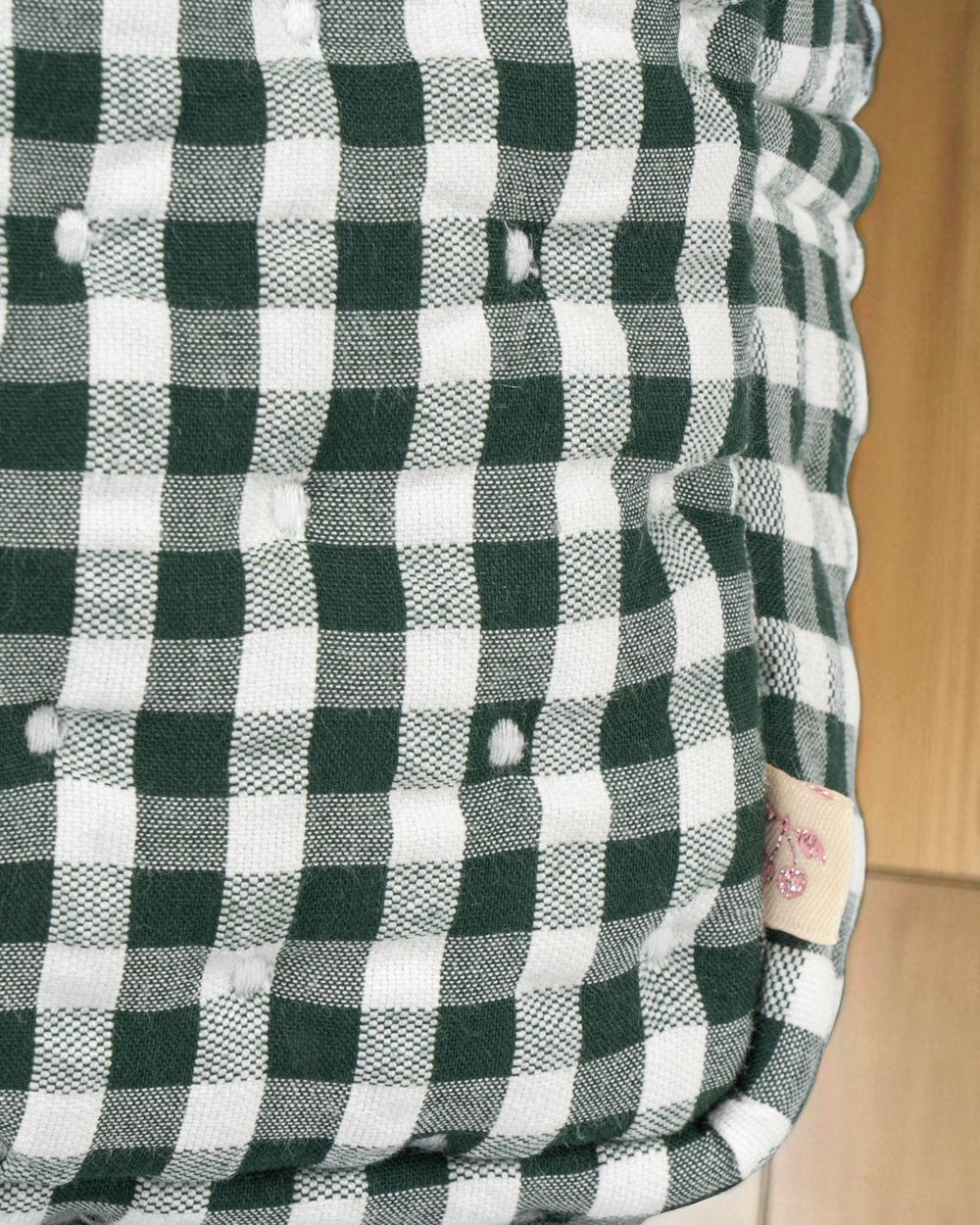 Side angle of structured canvas doll care bag in classic green check pattern