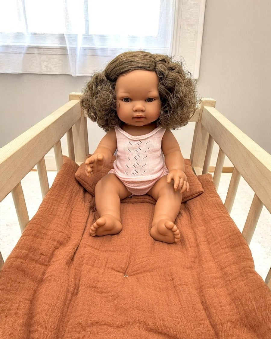 Lifelike Havana baby doll celebrating natural curls and diverse representation in pink pajama set