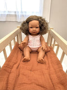 Lifelike Havana baby doll celebrating natural curls and diverse representation in pink pajama set