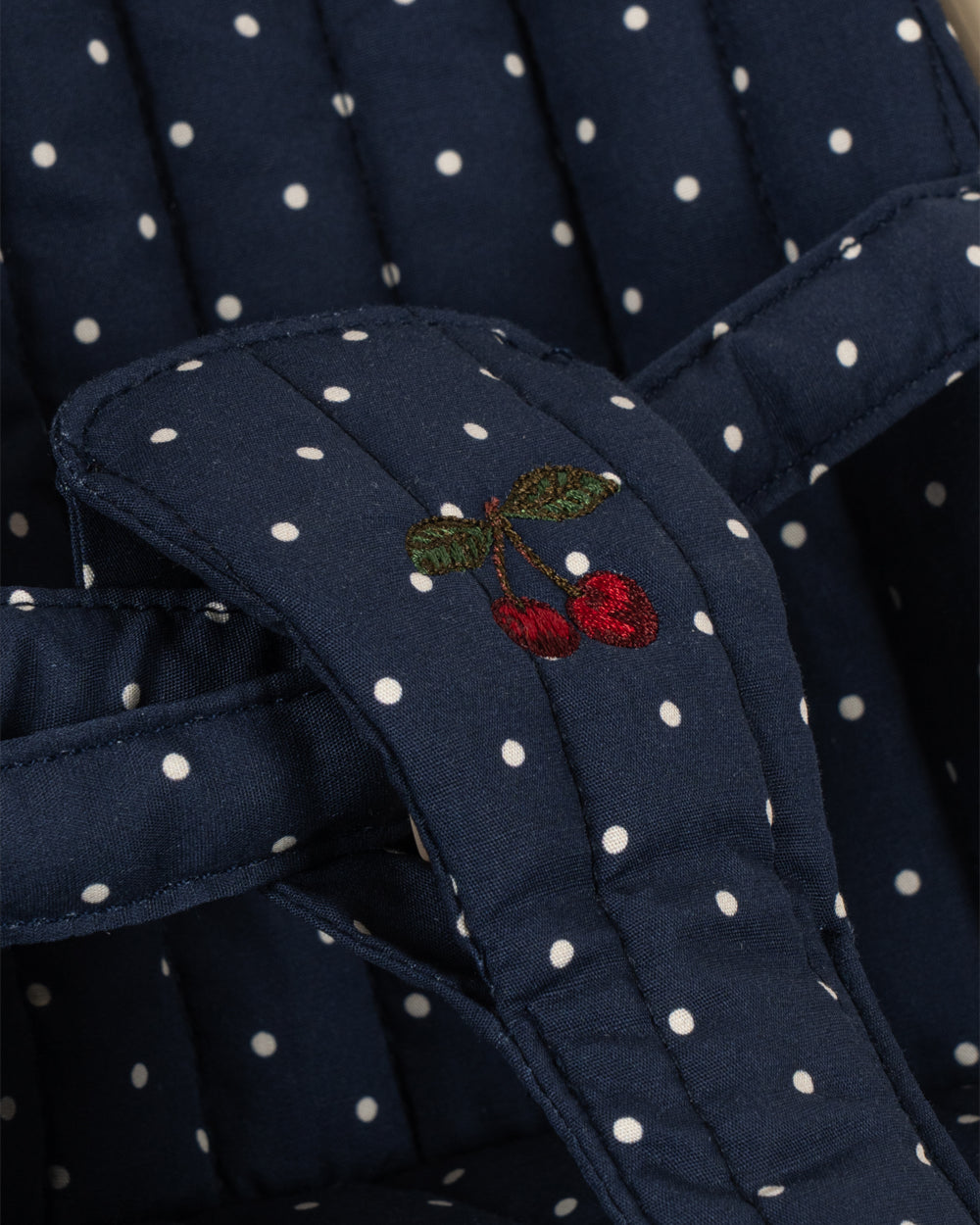 Navy blue fabric with white polka dots and a cherry embroidery detail.