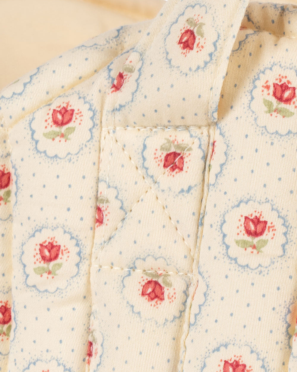 OEKO-TEX cotton bassinet showing cream fabric with botanical tulip pattern blue trim