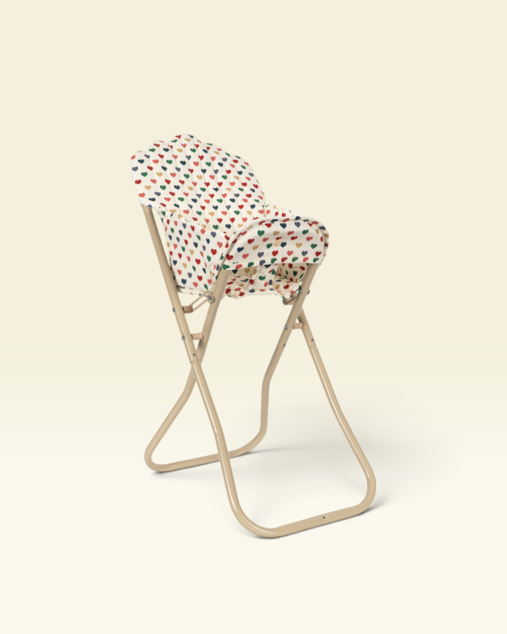 A beige folding chair with a white fabric seat cushion covered in a colorful red, green, and blue polka-dot pattern, set against a solid cream background.