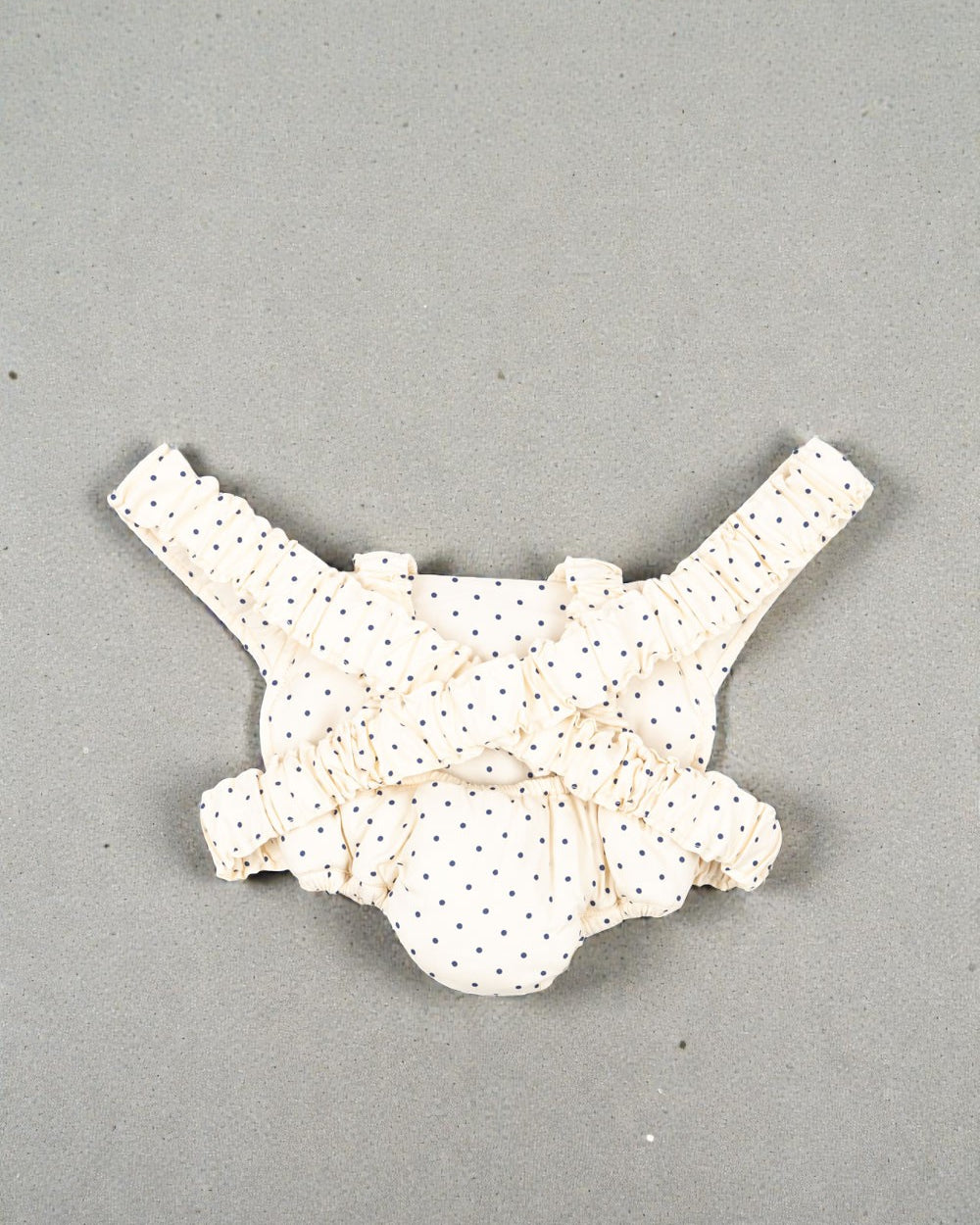 Navy dot baby carrier with elastic shoulder straps for hands-free doll play