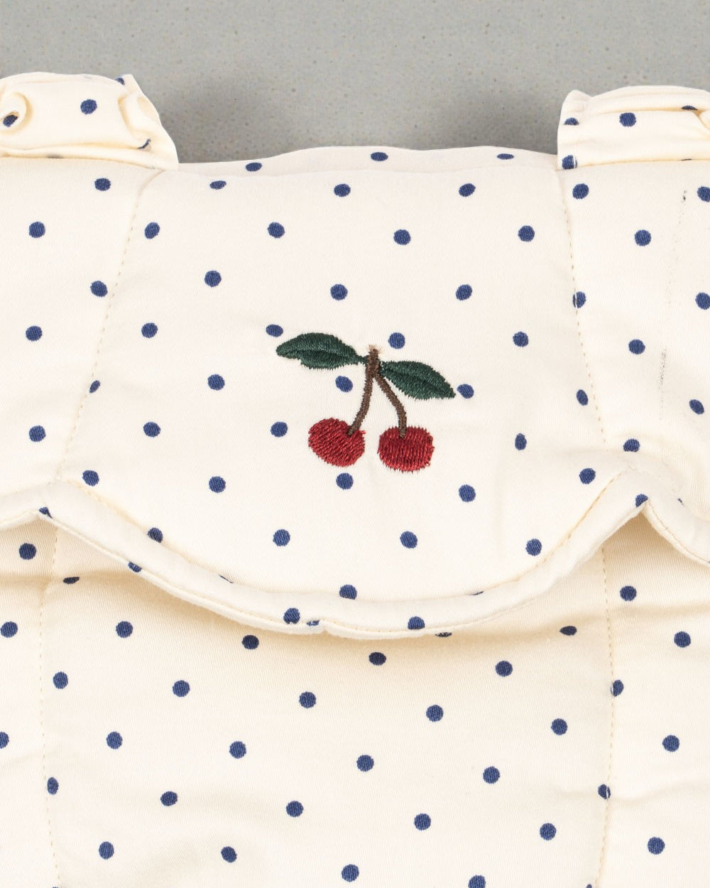 OEKO-TEX cotton doll carrier showing cream fabric with blue polka dot pattern