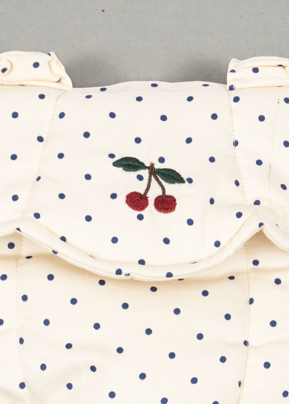 OEKO-TEX cotton doll carrier showing cream fabric with blue polka dot pattern