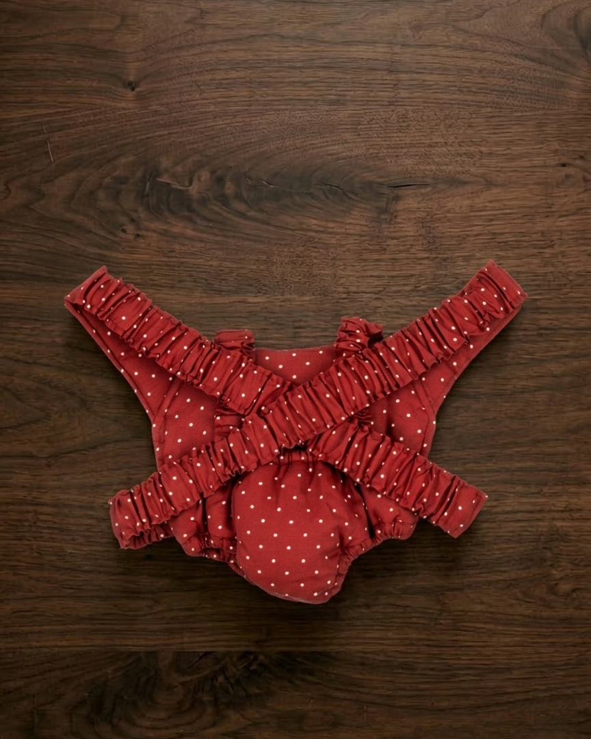 Back view of doll carrier showing adjustable elastic shoulder straps and quilted construction