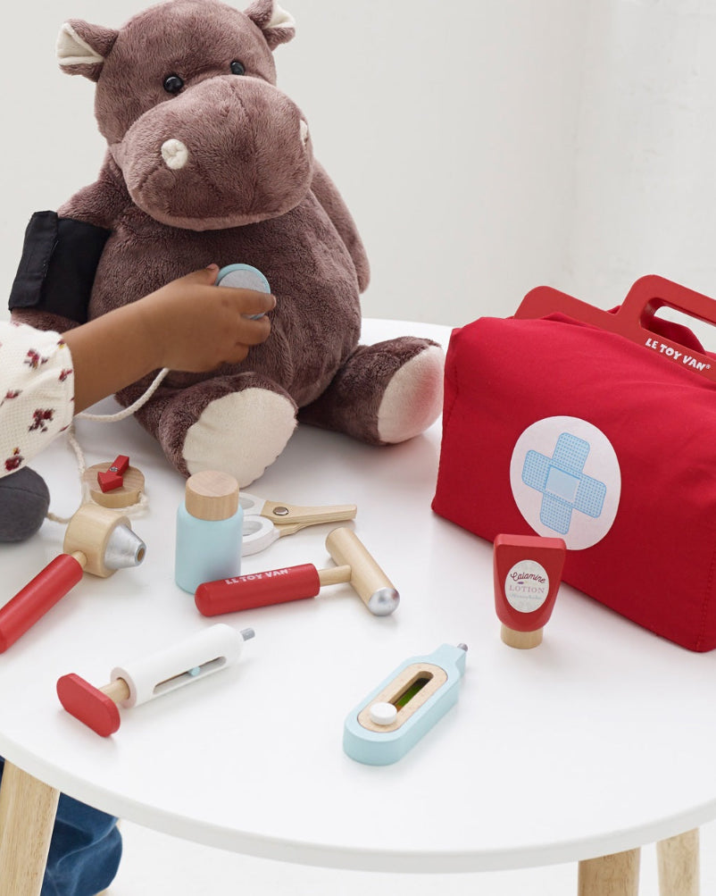 Child playing with Le Toy Van doctor kit during pretend medical care