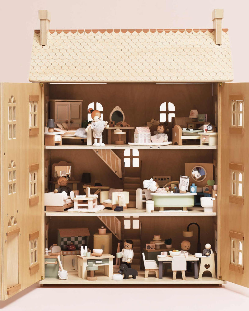 Detailed dollhouse with miniature furniture and accessories on a plain background