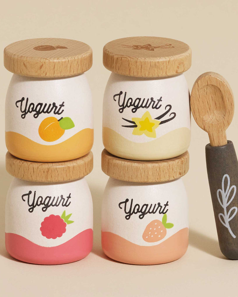 Four yogurt pots: apricot, vanilla, raspberry, strawberry