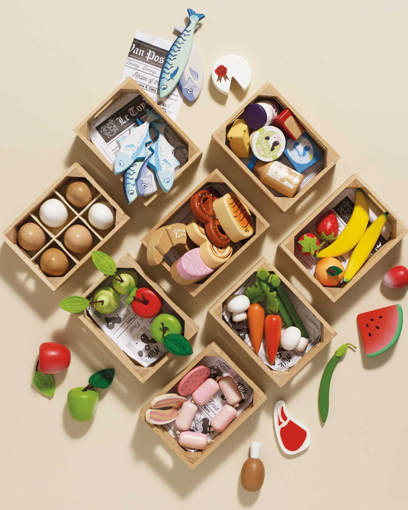 Wooden toy food set with various miniature food items on a beige background