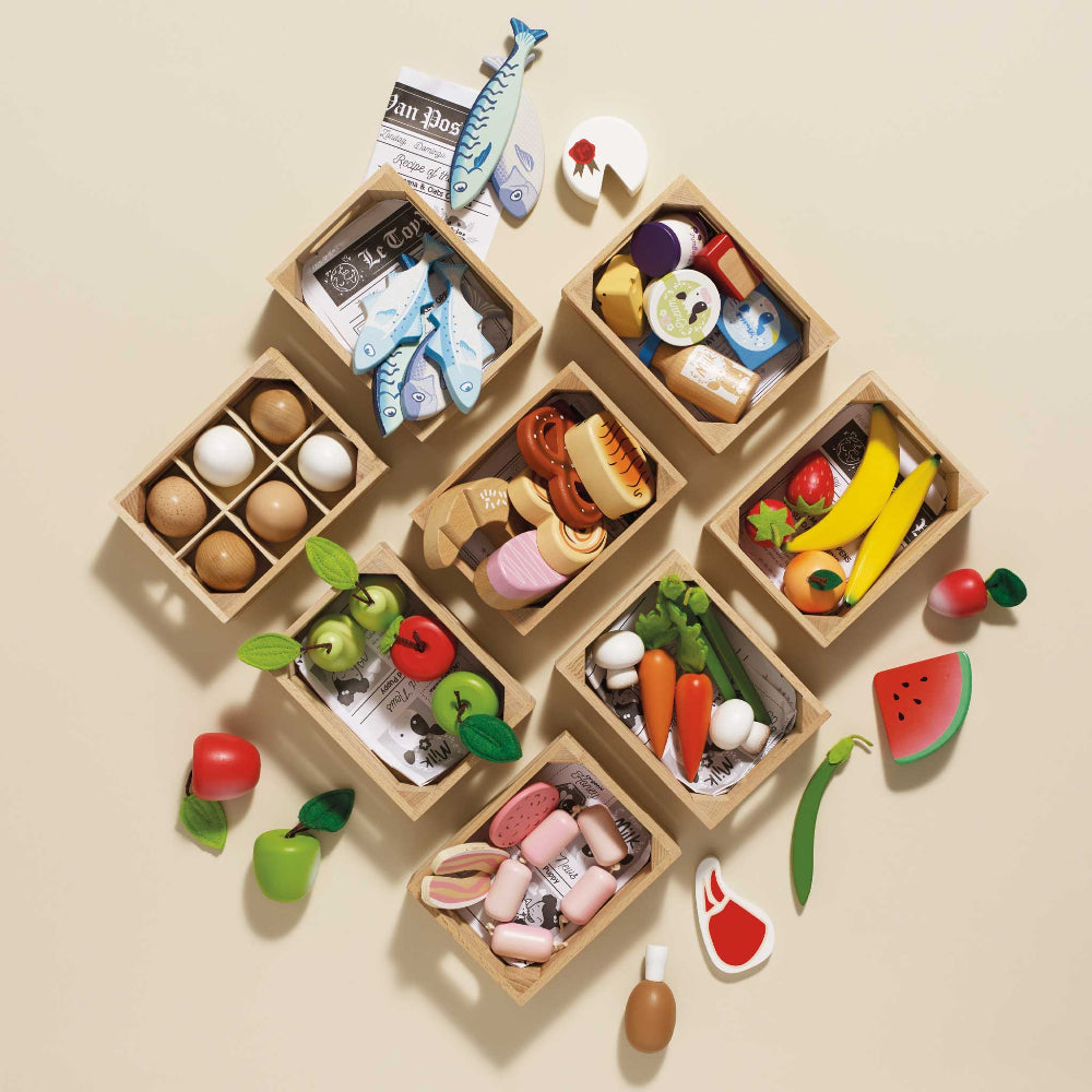 Wooden toy food set with various miniature food items on a beige background