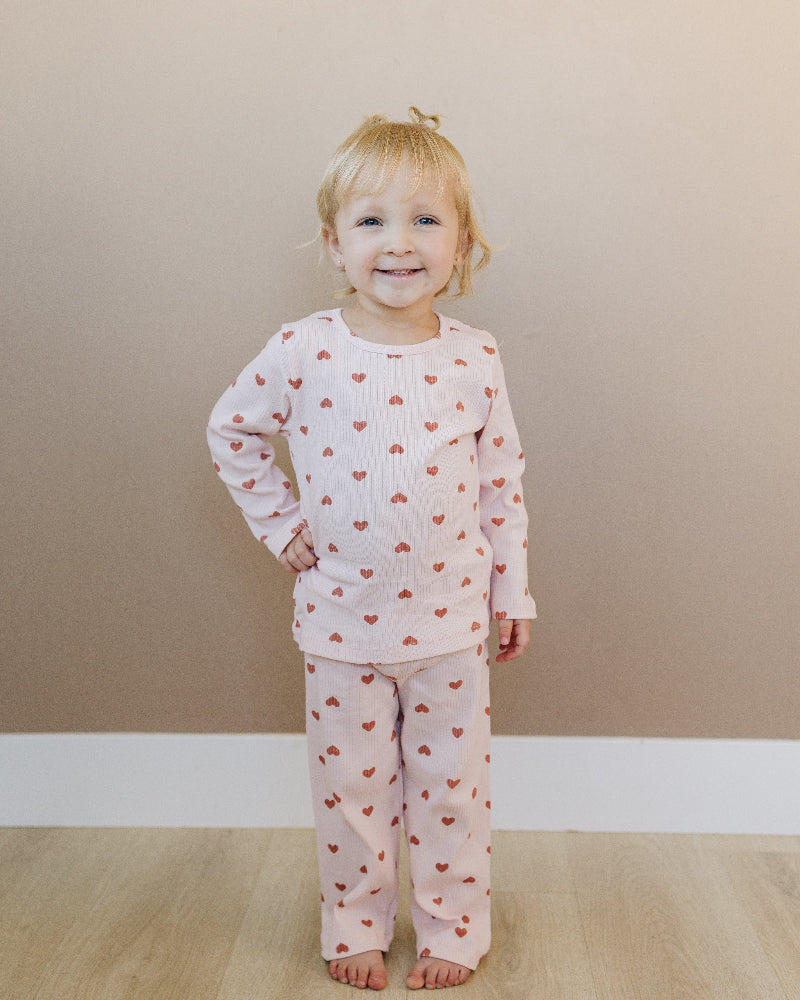 Toddler in sophisticated mauve heart print showing stretchy athletic fit