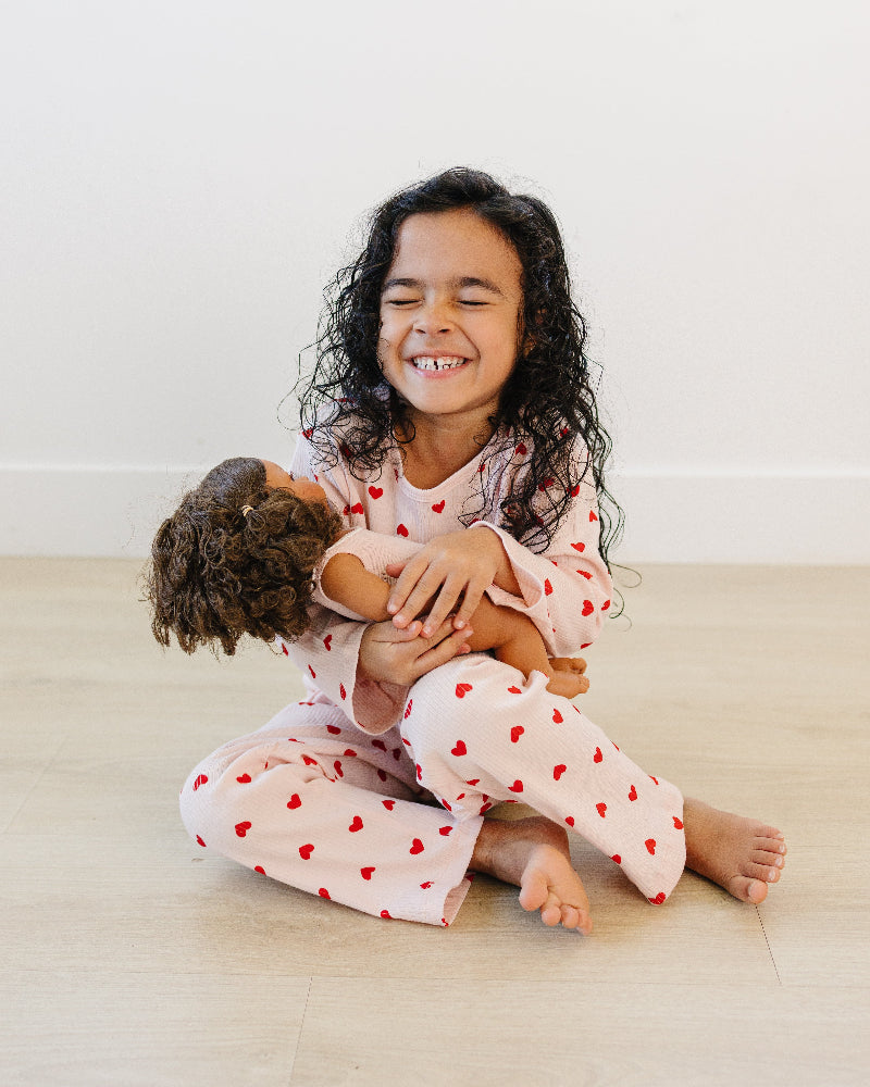 Toddler in blush pink heart print comfort wear showing stretchy movement and fit