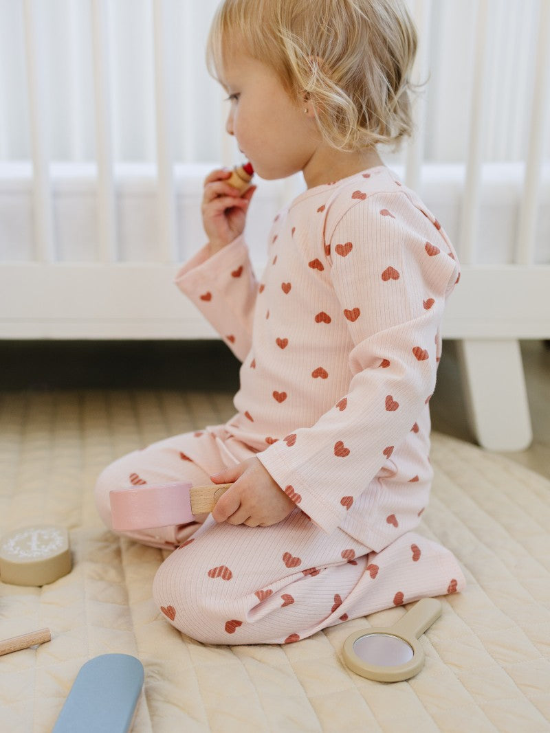 Kid playing in Dreamy Mauve Hearts premium comfort wear with blush pink base