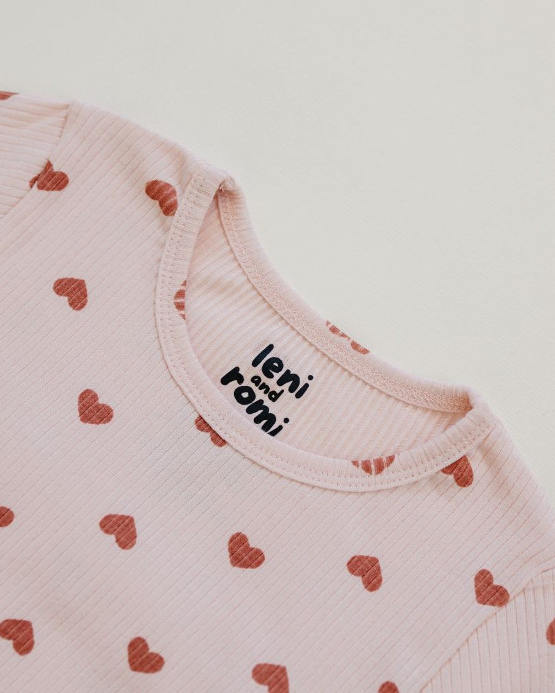 Detail of Leni & Romi tagless ribbed fabric with scattered mauve hearts design