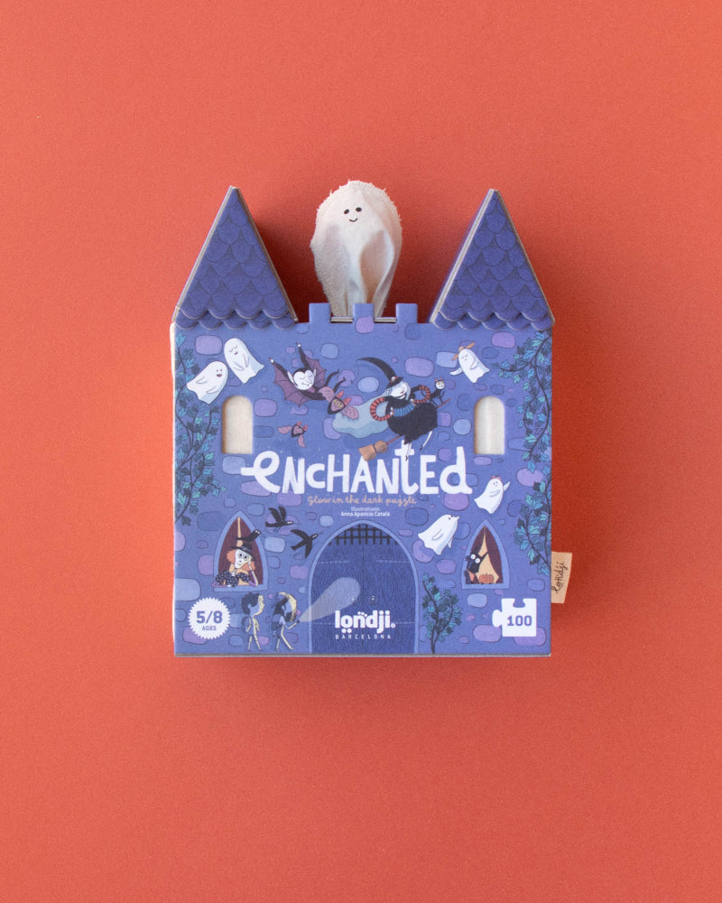 Blue castle-shaped box with a white plush toy on an orange background
