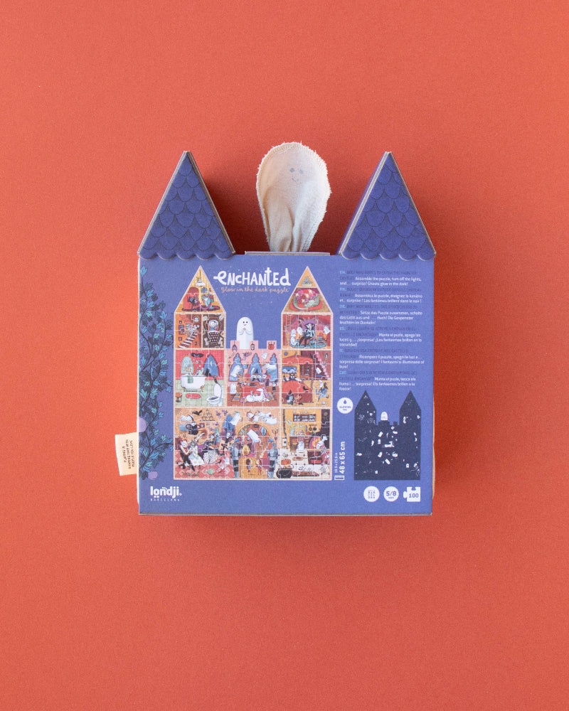 Blue house-shaped box with a white candle on an orange background