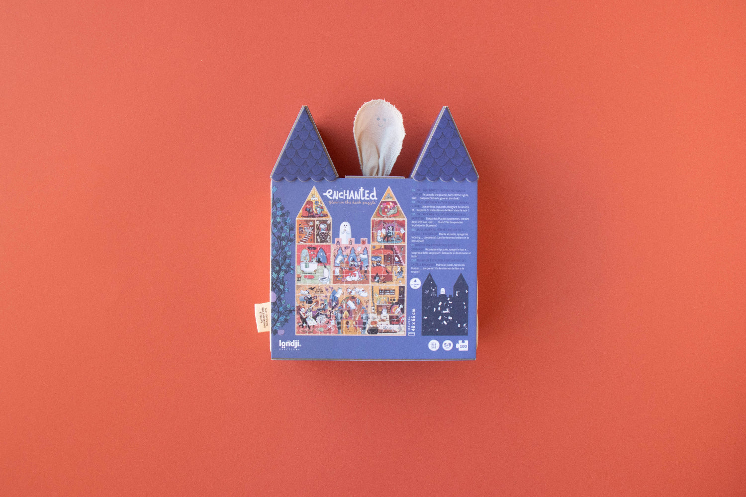 Blue house-shaped box with a white candle on an orange background