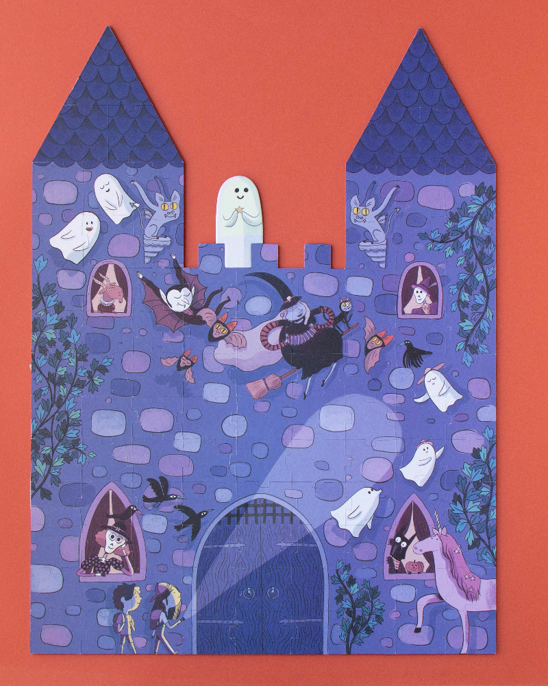 Decorative paper cutout of a haunted castle on an orange background