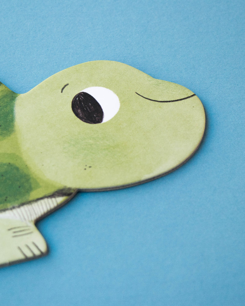 Green turtle-shaped puzzle piece on a blue background