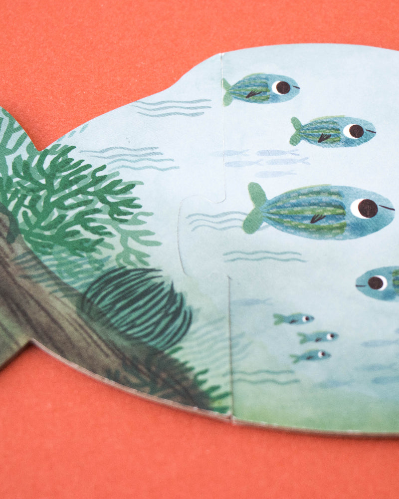 Fish-shaped puzzle with underwater scene on an orange background